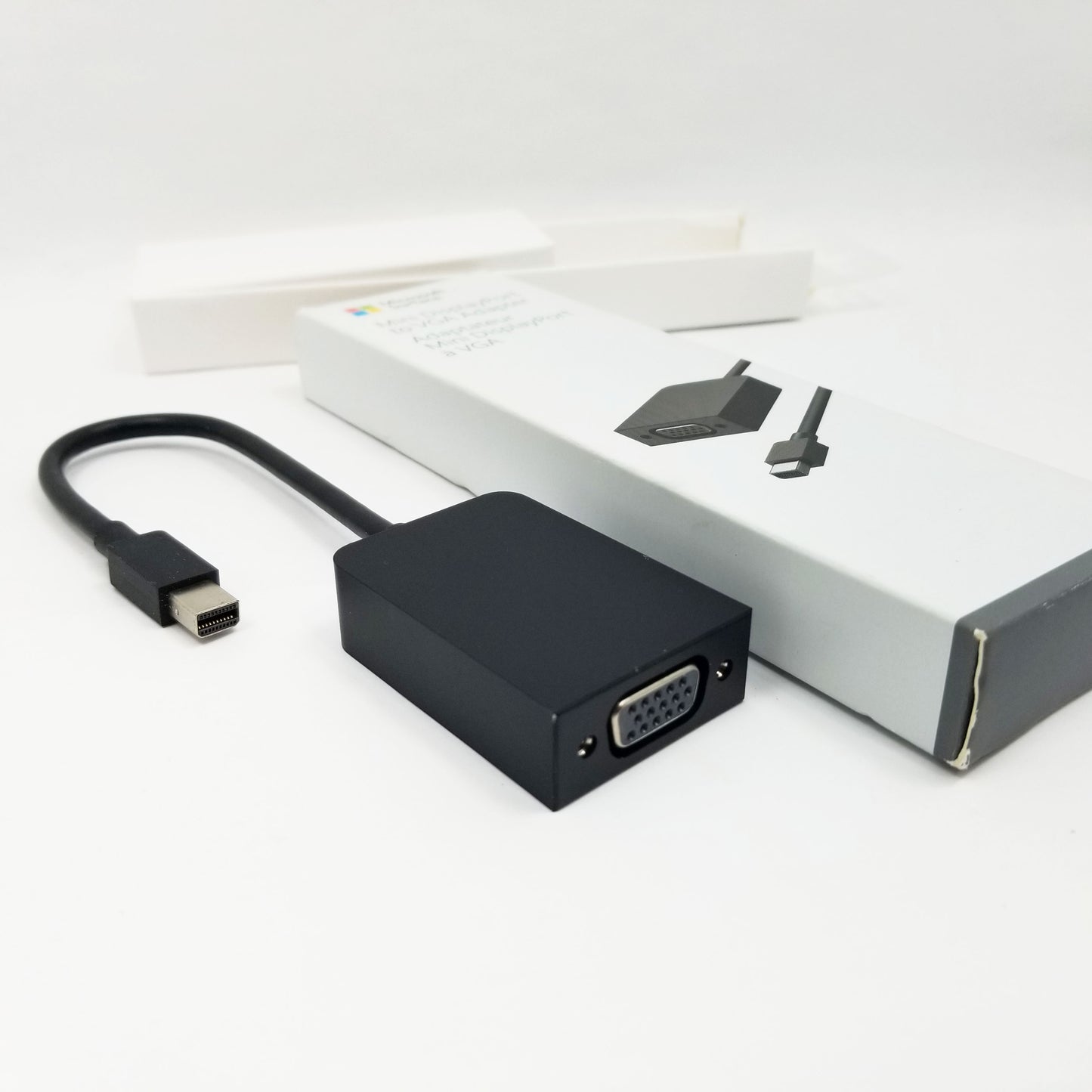 VGA adapter next to retail packaging on a white background
