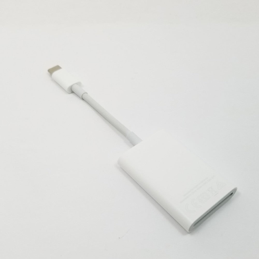 USB-C to SD card adapter resting diagonally on a light gray surface