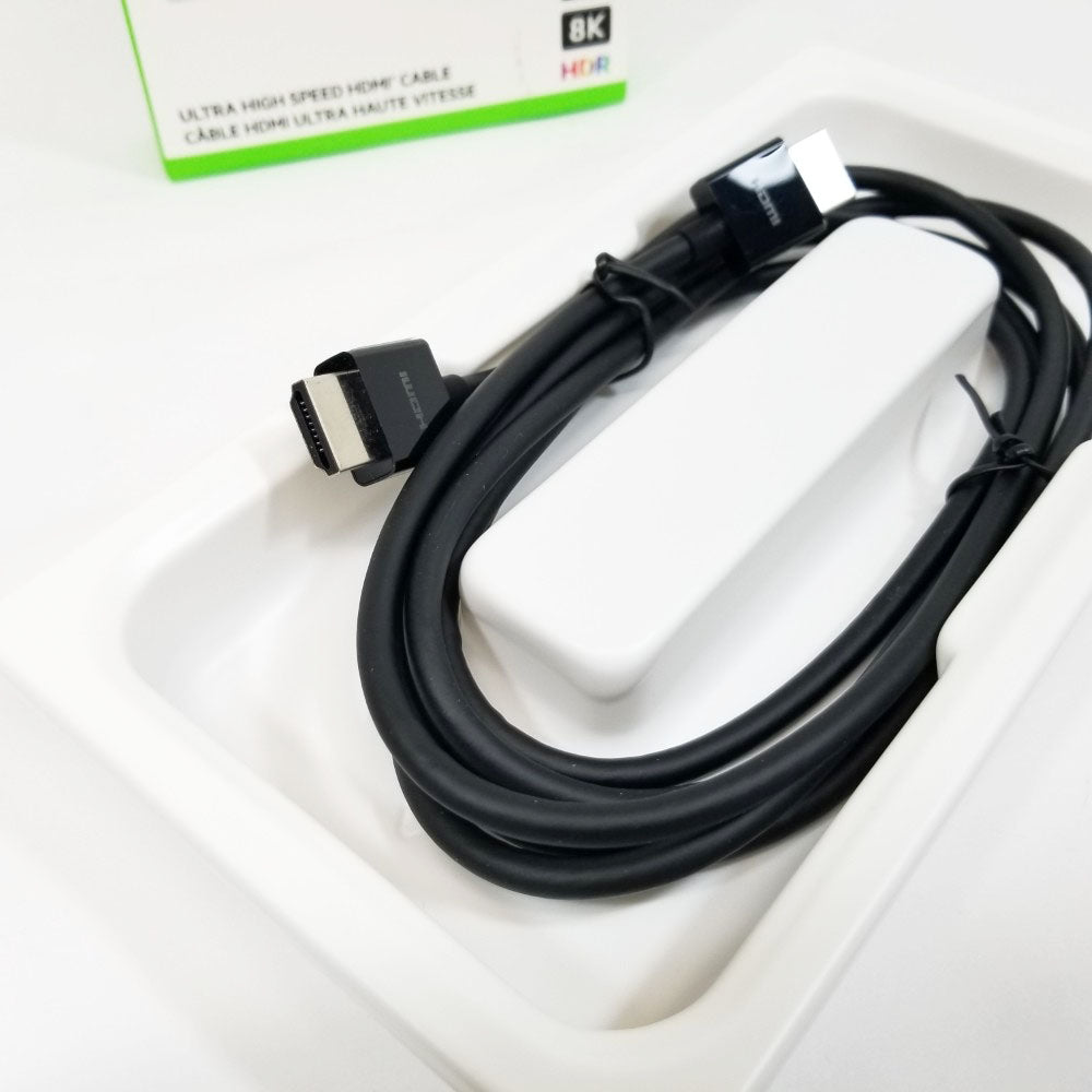 Black HDMI cable on a white surface with a green box in the background