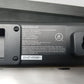 Back panel of an Insignia mini soundbar showing label with part number on a light gray background