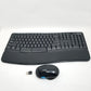 Black ergonomic keyboard and mouse set with Microsoft logo, wireless receiver on a white background