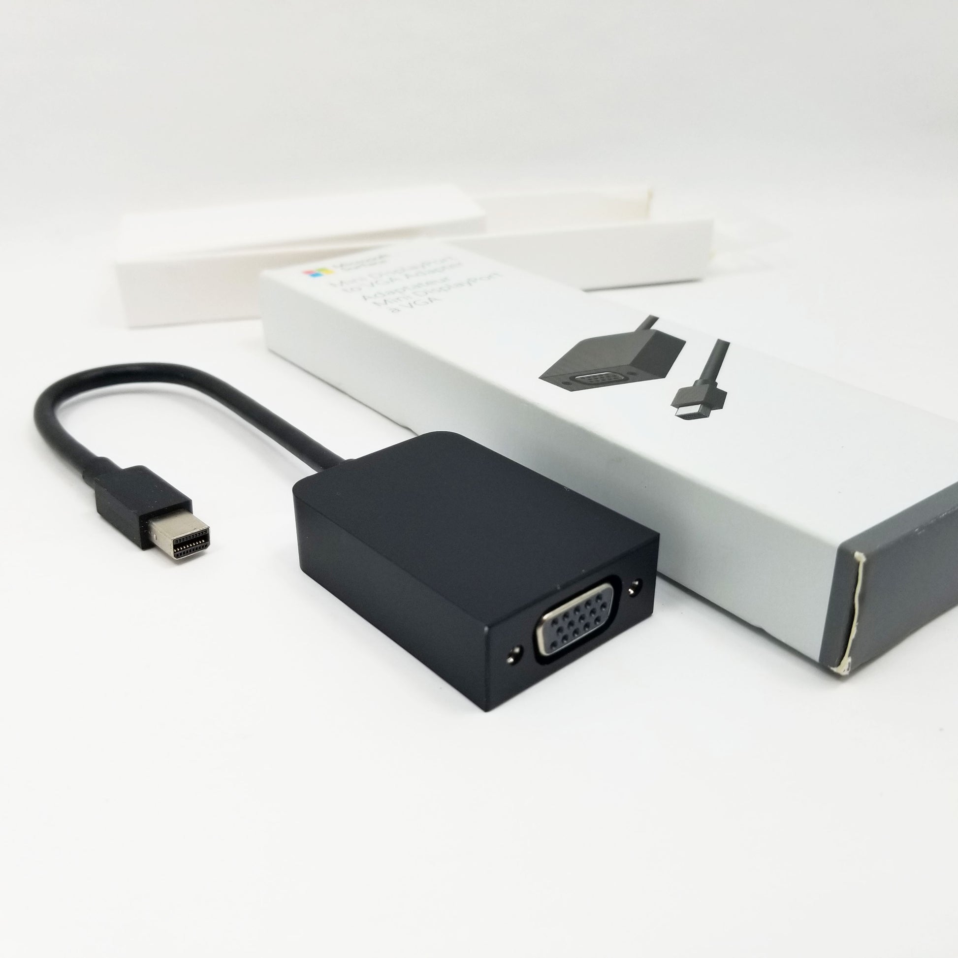 VGA adapter next to retail packaging on a white background