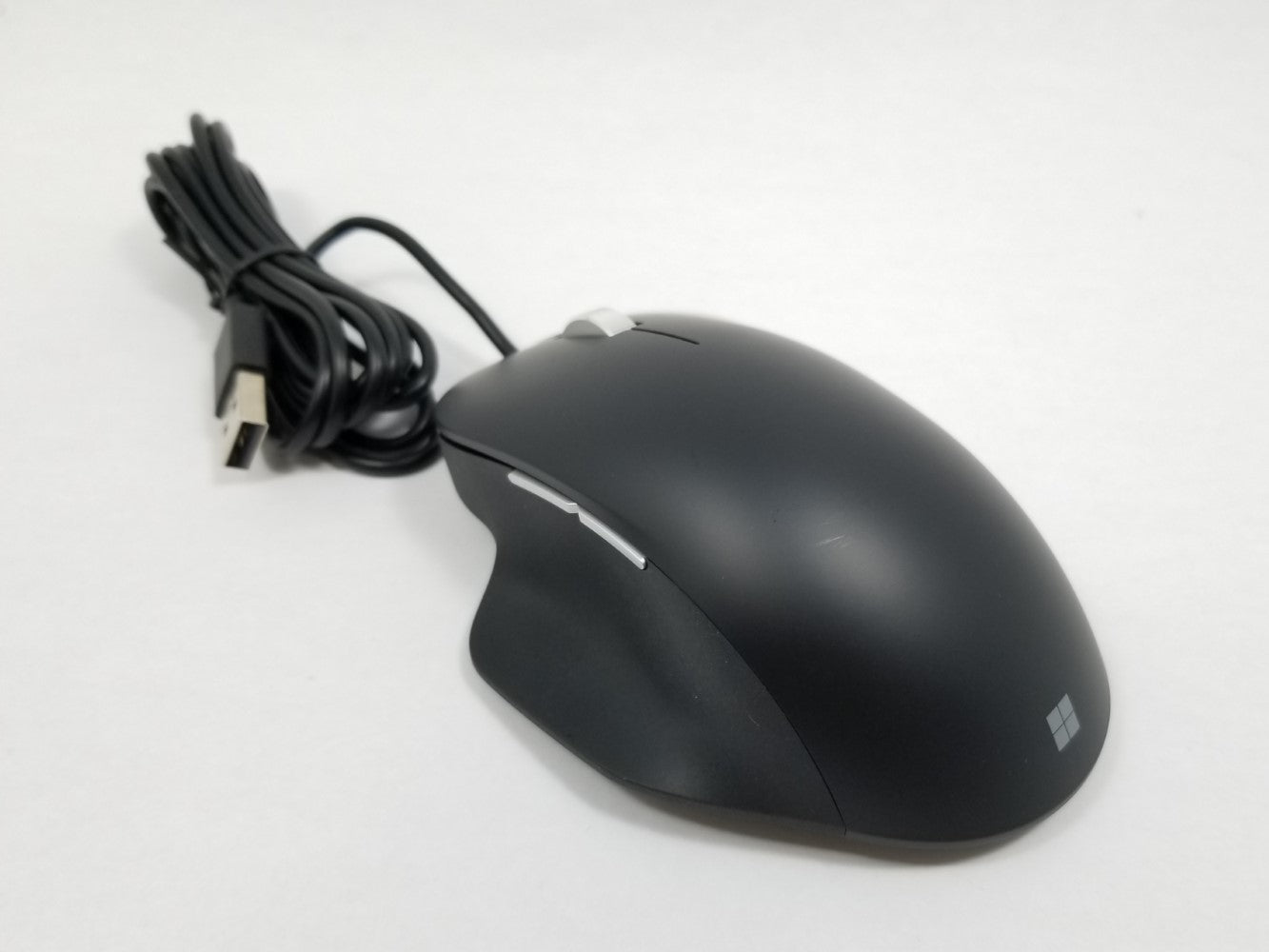 Black computer mouse with USB cable on a white background