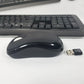 Side profile of Microsoft wireless desktop 850 mouse and wireless receiver with keyboard in the background.