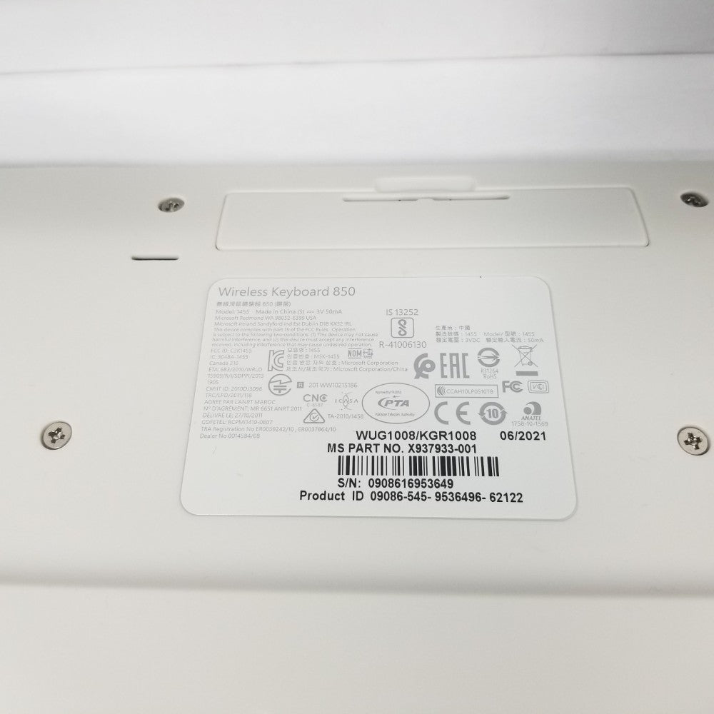 Close-up of Manufacturer label sticker with inscriptions on the under side of keyboard.