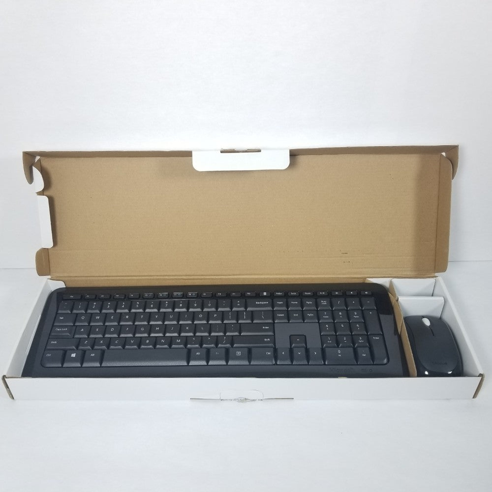Black Microsoft wireless desktop 850 Keyboard and mouse inside of open retail packaging.
