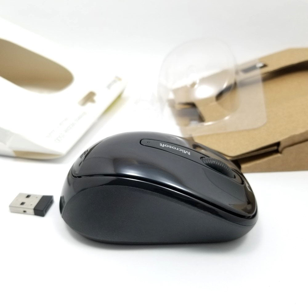 Side view of mouse and transmitter on white surface.