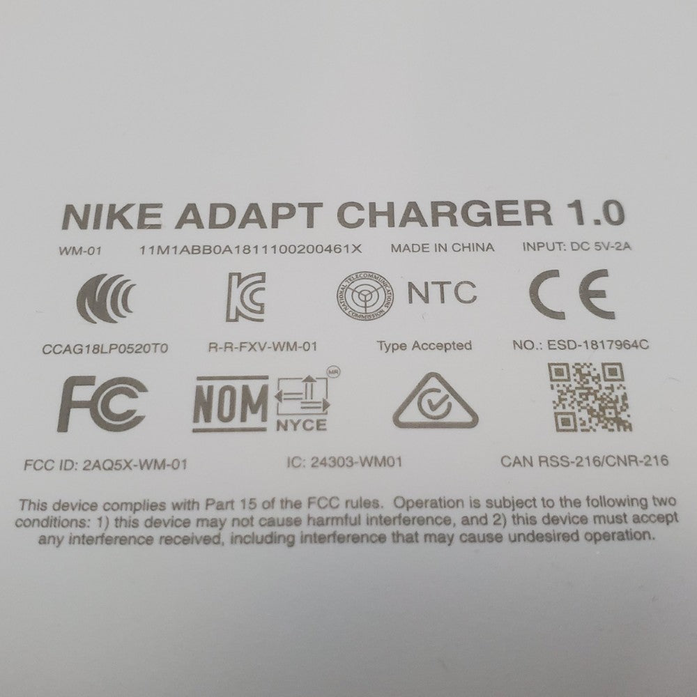 Close up of manufacturer inscriptions on the bottom surface of Nike adapt charging mat.