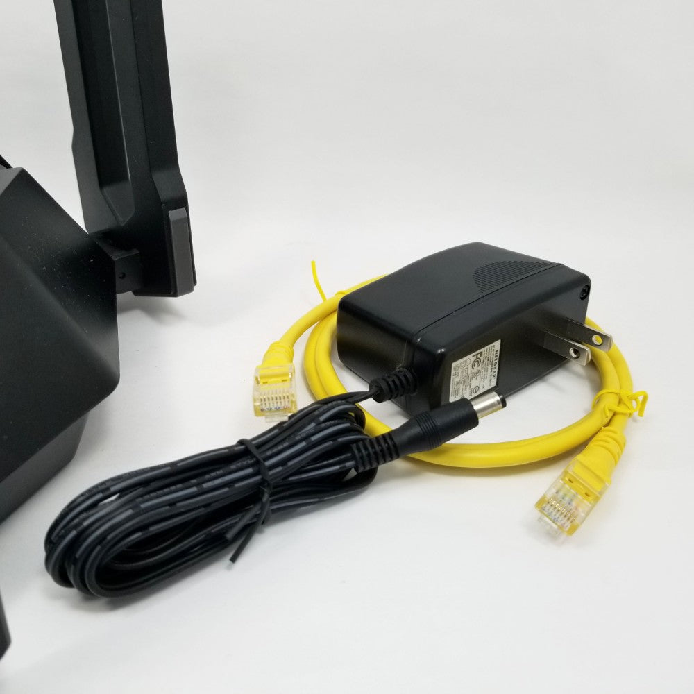Black power adapter with yellow ethernet cables on a white background
