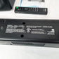 Back of a Sony soundbar showing manufacturer label tag. Remote control sitting to the al on a white surface