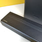Samsung HW-Q60T soundbar on a white surface with a yellow wall in the background