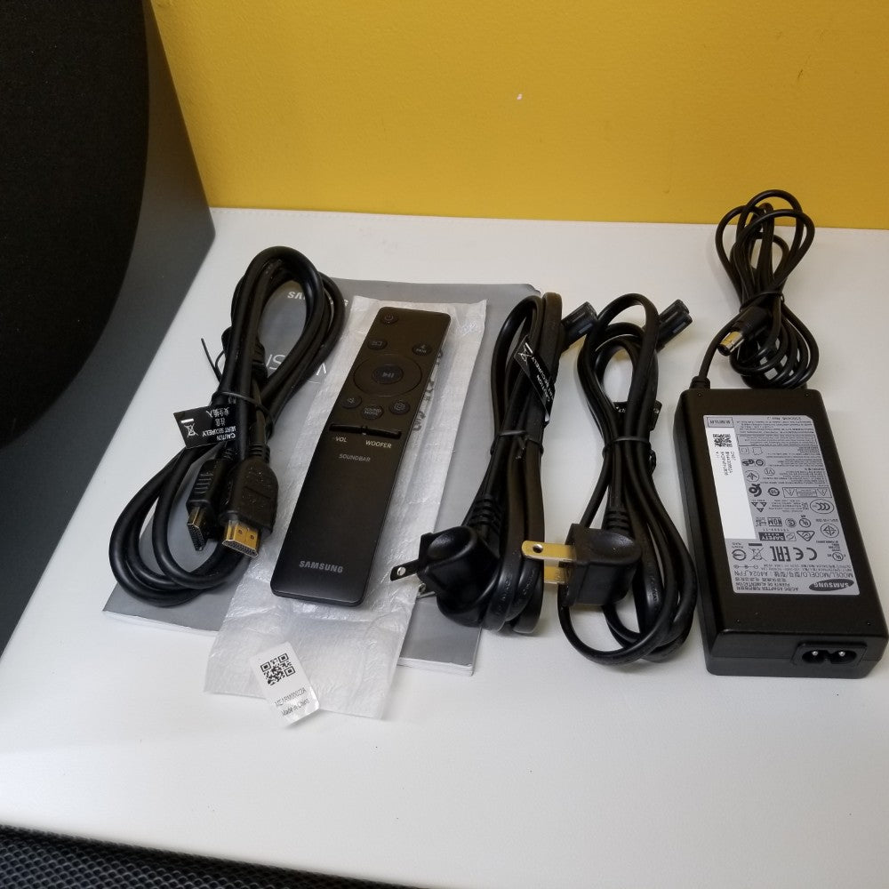 Samsung HW-Q60T Remote Charger and cables on a white surface with a yellow background