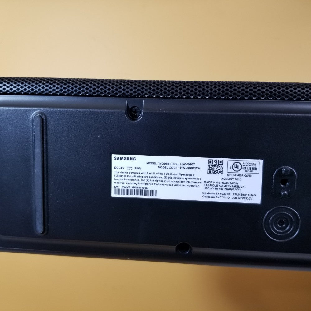 Back view of a Samsung HW-Q60T showing manufacturer labeling on a beige surface
