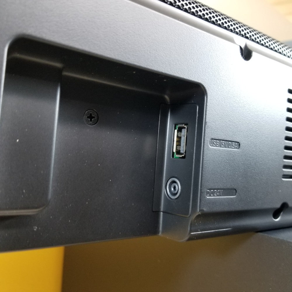Close-up of a Samsung HW-Q60T with USB and power ports on a yellow background